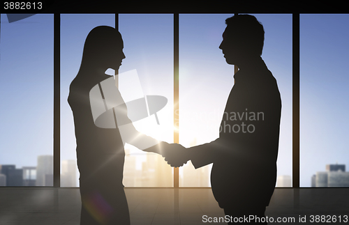 Image of business partners silhouettes shaking hands