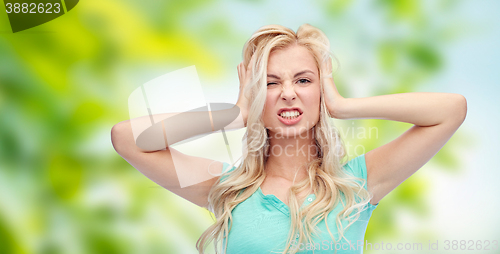 Image of young woman holding to her head and screaming