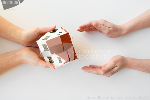 Image of close up of hands giving house or home model