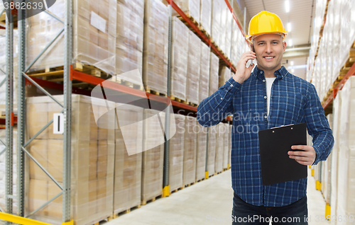 Image of man with clipboard and smartphone at warehouse