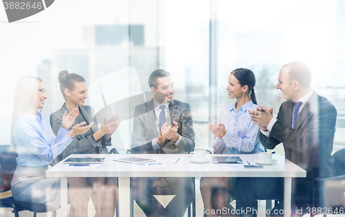 Image of business team with laptop clapping hands