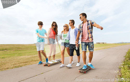 Image of happy teenage friends with longboards outdoors