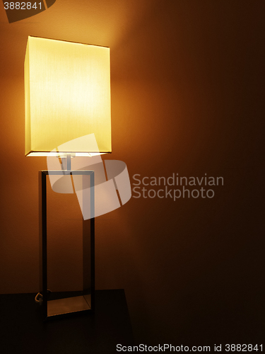 Image of Illuminated table lamp in a dark room