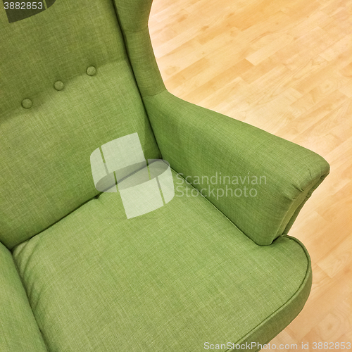 Image of Stylish green armchair on wooden floor