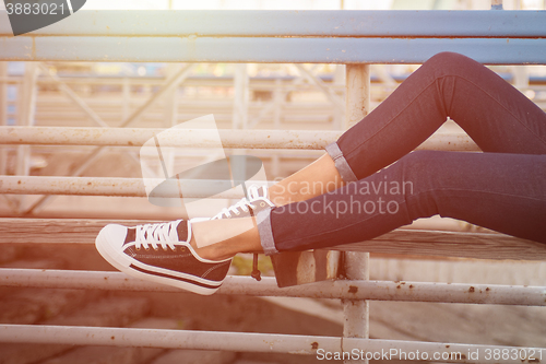 Image of closeup of woman legs in white gumshoes