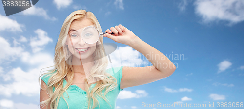 Image of happy young woman with magnifying glass