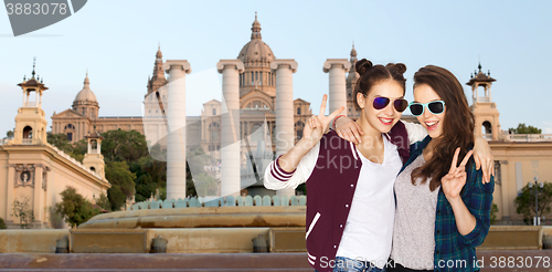 Image of smiling teenage girls in sunglasses showing peace