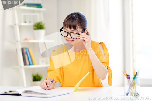 Image of happy asian young woman student learning at home