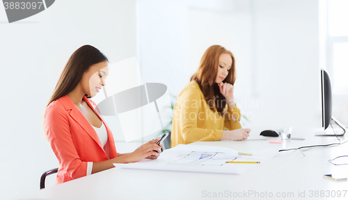 Image of businesswoman texting on smartphone at office