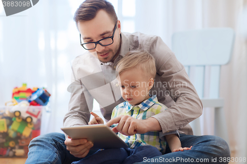 Image of father and son with tablet pc playing at home