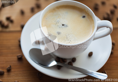 Image of close up coffee cup and grains on wooden table