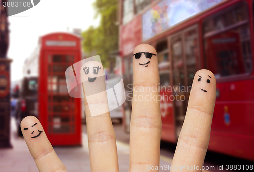 Image of close up of four fingers with smiley faces