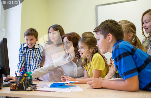 Image of group of kids with teacher and computer at school