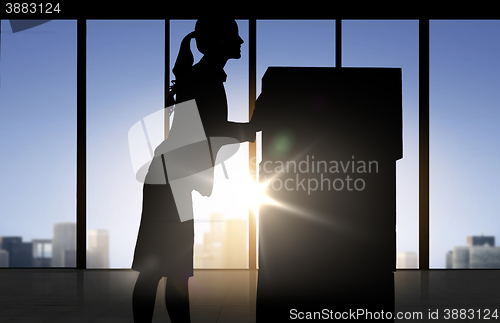 Image of silhouette of businesswoman moving boxes at office