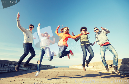 Image of smiling friends in sunglasses laughing on street