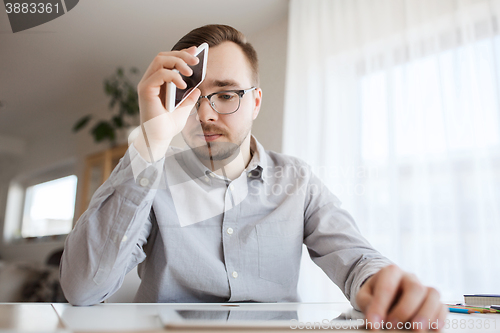 Image of businessman with smarphone at home office