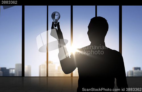 Image of silhouette of businessman holding light bulb