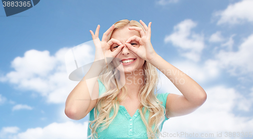 Image of young woman looking through finger glasses