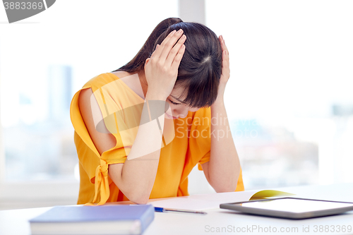 Image of stressed asian young woman student at home