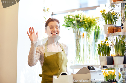 Image of smiling florist woman at flower shop cashbox