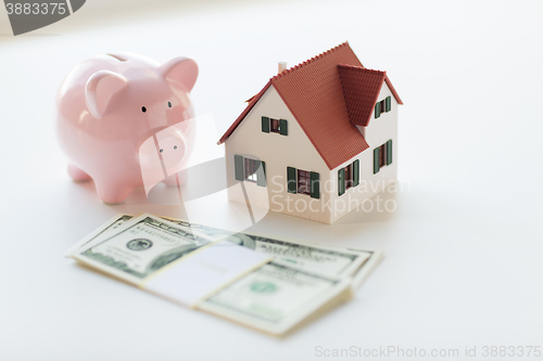 Image of close up of house model, piggy bank and money