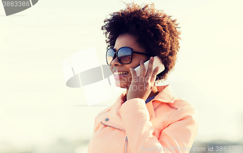Image of smiling african american woman with smartphone