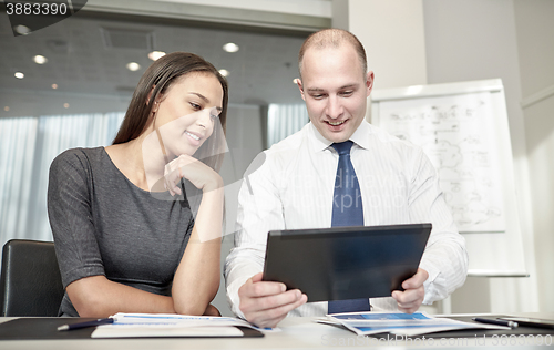 Image of smiling businesspeople with tablet pc in office