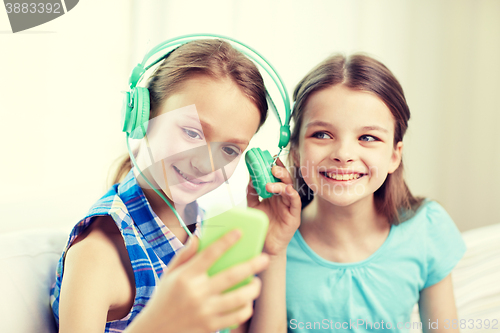 Image of happy girls with smartphone and headphones