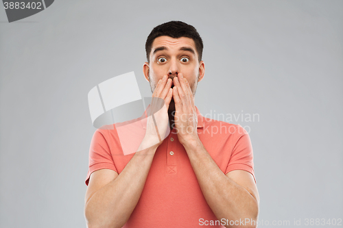 Image of scared man in polo t-shirt over gray background