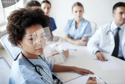 Image of female doctor over group of medics at hospital