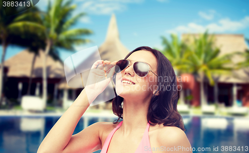 Image of happy woman in sunglasses and swimsuit on beach