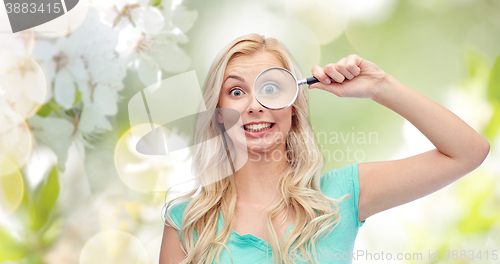 Image of happy young woman with magnifying glass