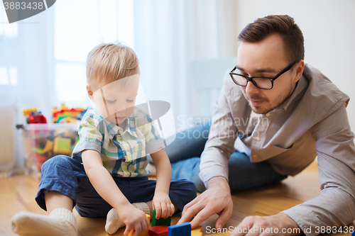 Image of father and son playing with toy blocks at home