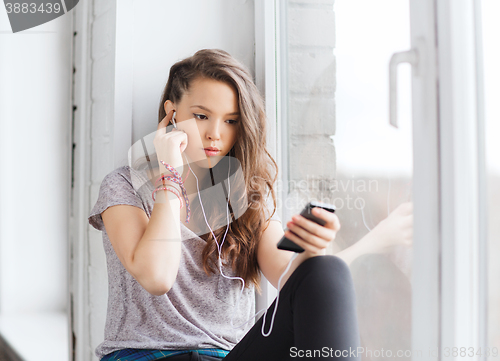 Image of teenage girl with smartphone and earphones