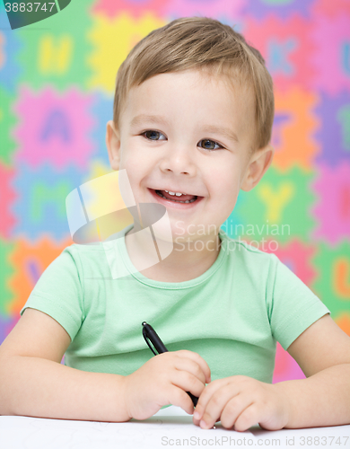 Image of Little boy is writing on his copybook