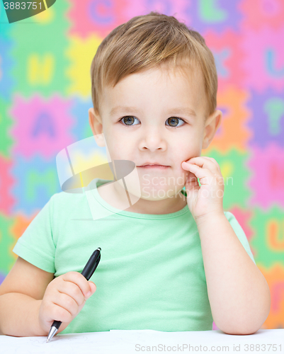 Image of Little boy is writing on his copybook