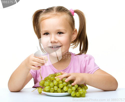 Image of Little girl is eating grapes