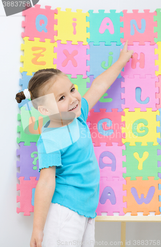 Image of Little girl is pointing at letter N