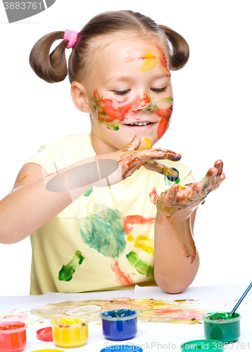 Image of Portrait of a cute girl playing with paints