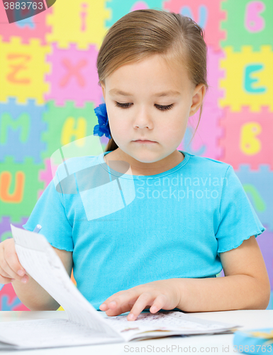 Image of Little girl is writing using a pen