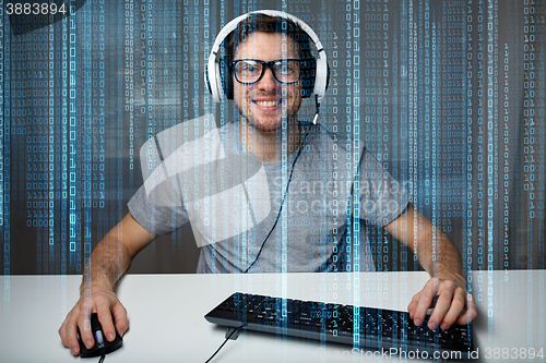 Image of man in headset playing computer video game at home