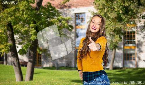 Image of happy young woman or teen girl showing thumbs up