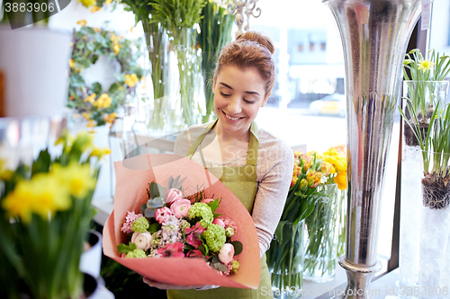 Image of smiling florist woman with bunch at flower shop