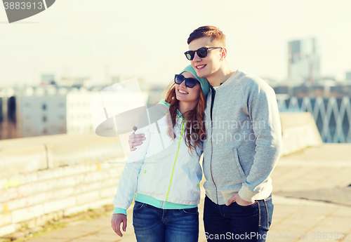 Image of happy teenage couple walking in city