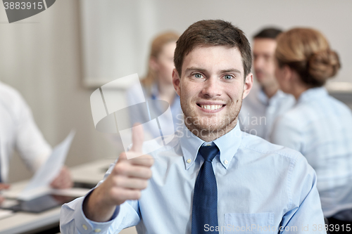 Image of group of smiling businesspeople meeting in office