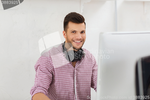 Image of creative man with headphones and computer