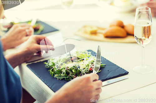 Image of close up of woman eating salad at restaurant