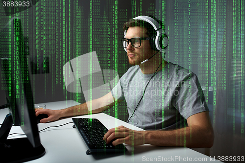 Image of man in headset playing computer video game at home