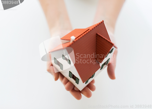 Image of close up of hands holding house or home model