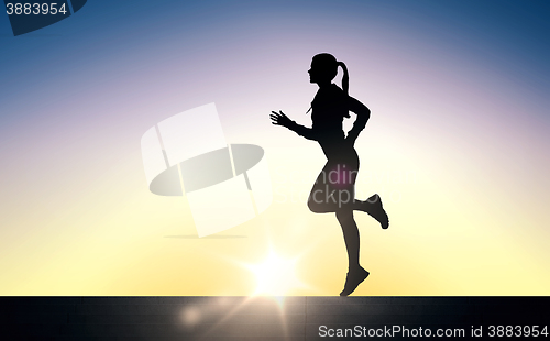 Image of happy young sports woman running outdoors